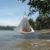 Anwendungsbeispiel - zwei Personen in einem Singel Zelt - dies hängt an einem Baum direkt am Strand - im Hintergrund iund unter dem Zelt ist das Wasser zu sehen - andere Perspektive Nr.2